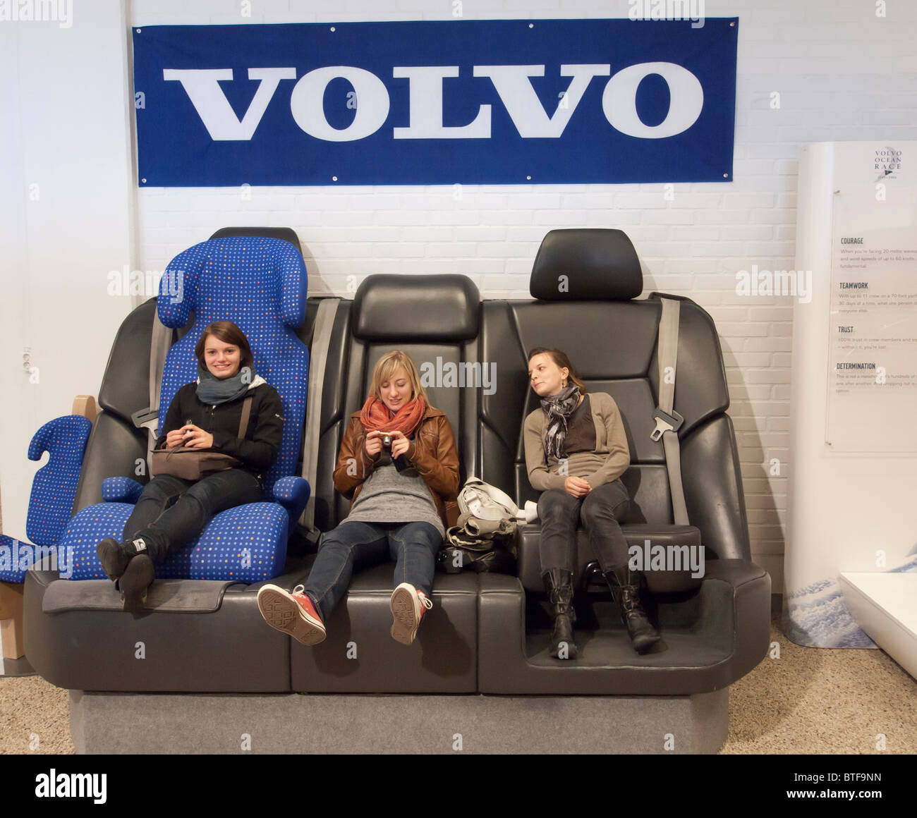 Young female visitors relaxing on oversized seats at Volvo Museum in Gothenburg Sweden Stock Photo