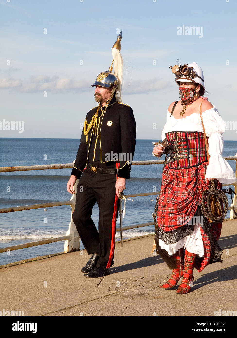 A man and woman in pseudo Military Dress on the pier at the Whitby Goth Week End 2010 Stock Photo