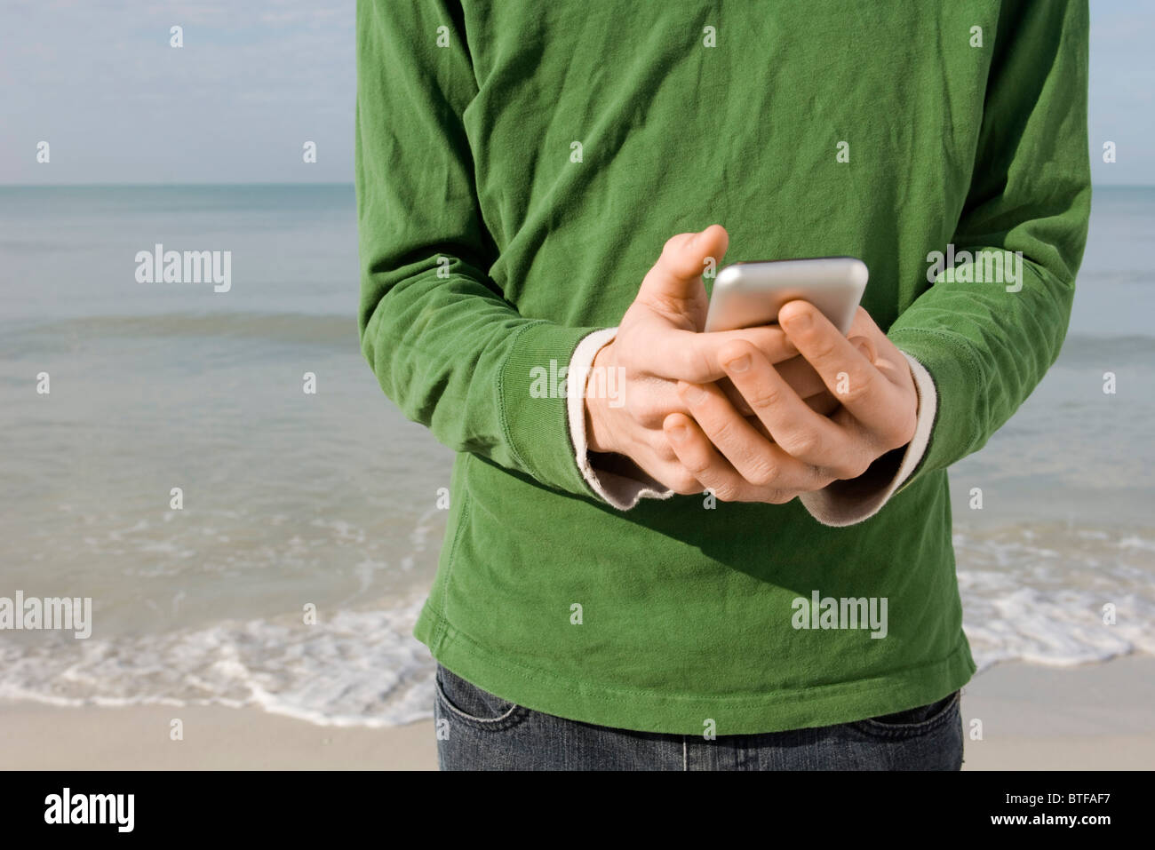 Text messaging at the beach Stock Photo