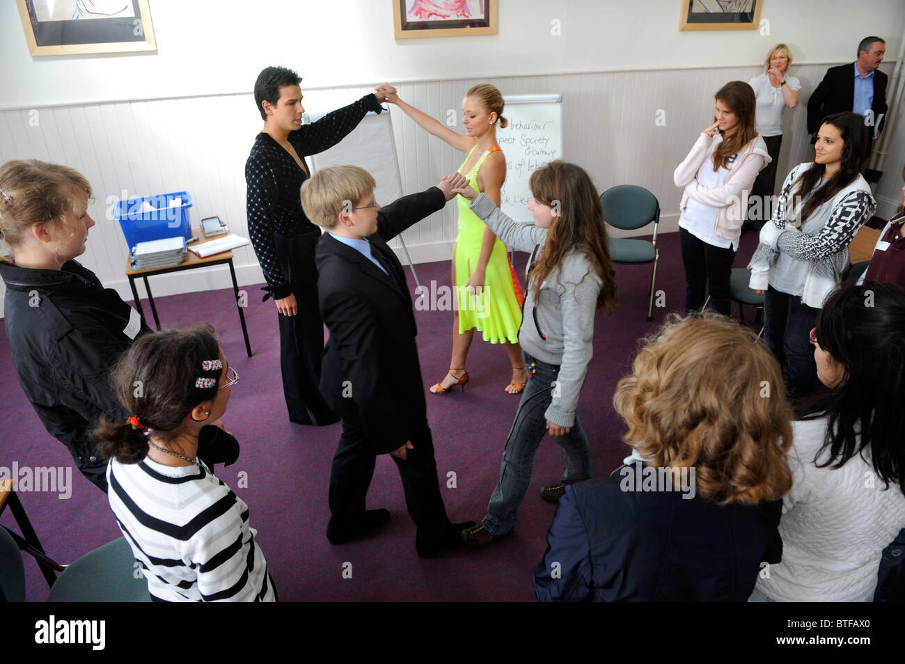 Slovakian ballroom dancers Metej Chren & Miroslava Kosorinova demonstrate good and bad examples of etiquette to a class of overs Stock Photo