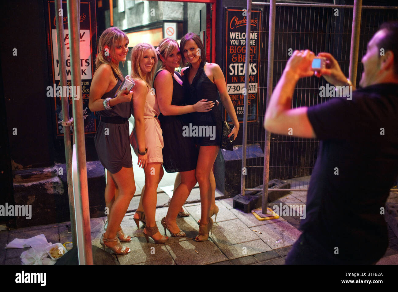 A group of young women poses to a photo on Caroline street in the city centre of Cardiff on a Saturday night. Stock Photo
