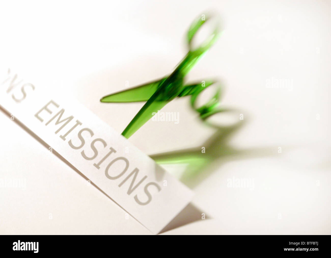 Emission reduction concept depicting green scissors cutting emissions graphic. Stock Photo