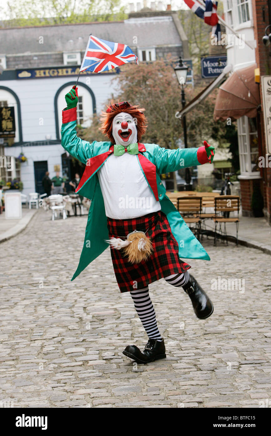 Clown entertainer with tartan kilt and union jack flag, Windsor, Berkshire, UK Stock Photo