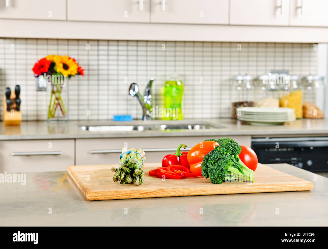 Modern kitchen interior with fresh vegetables on natural stone countertop Stock Photo