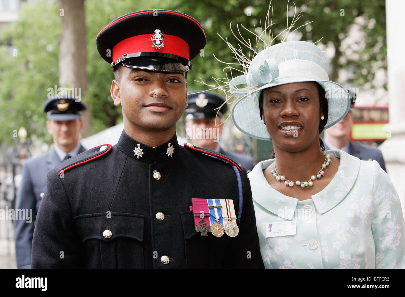 Private Johnson Beharry with Victoria Cross VC medal for bravery acompanied by his partner at Westminster Abbey, London Stock Photo