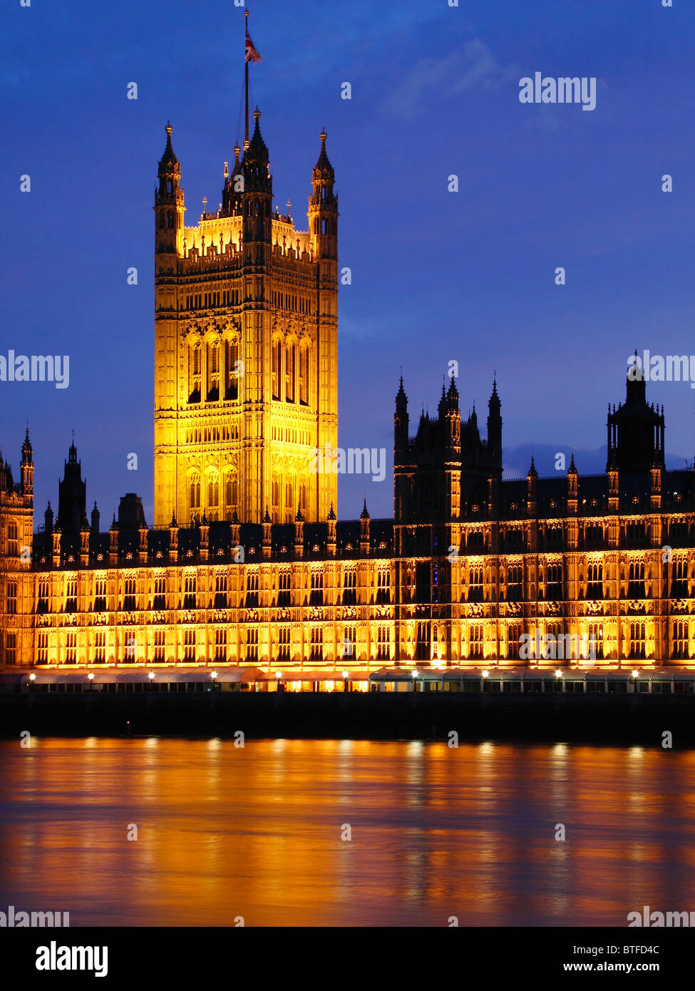 The tower of the British parliament building at dusk lit by lights with the blue skies in the background. Stock Photo