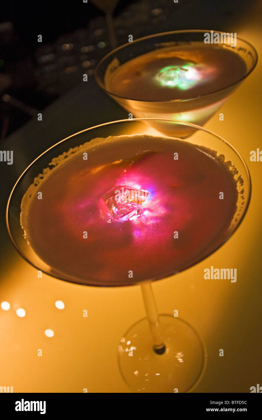 Ginger Cosmo, an alcoholic drink lit by a plastic ice cube that changes color Stock Photo