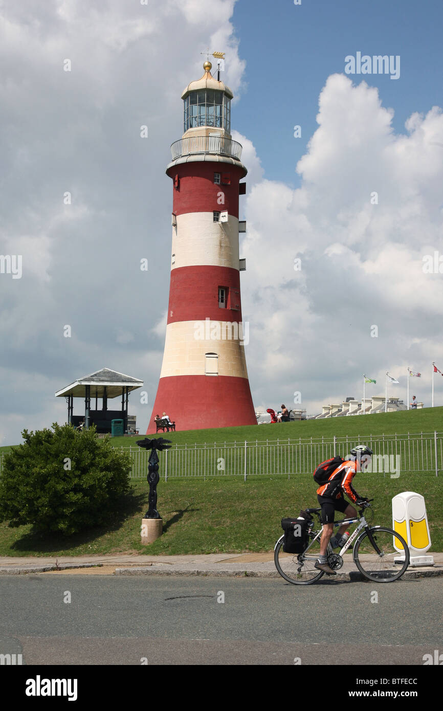 Cyclist passes Smeaton's Tower on Plymouth Hoe in Devon Stock Photo