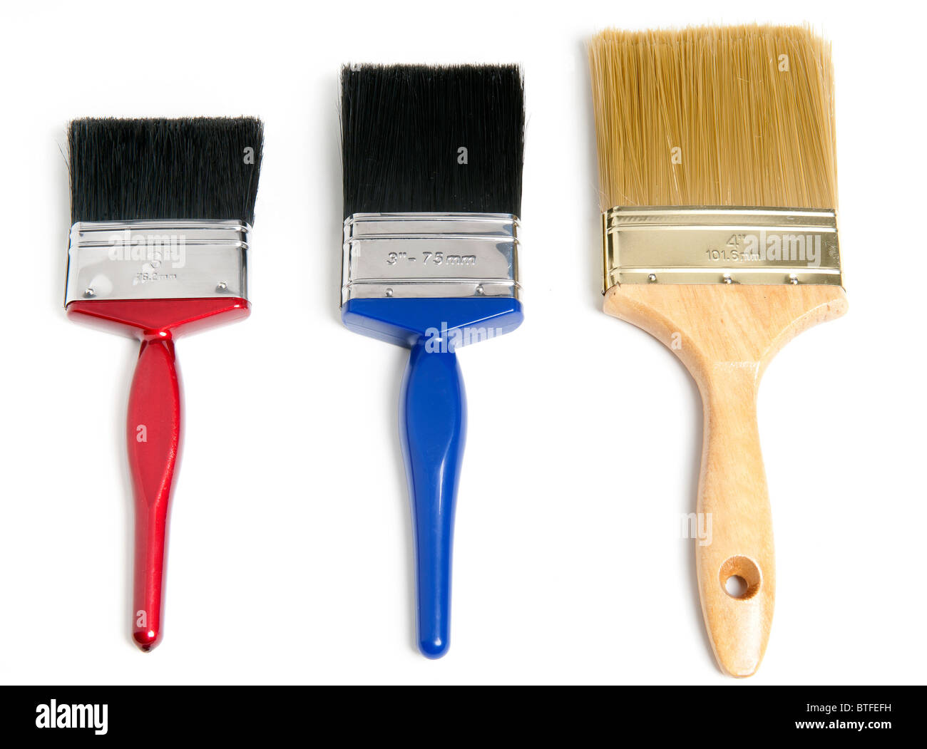 Three 3 paintbrushes of various sizes against white studio background Stock Photo
