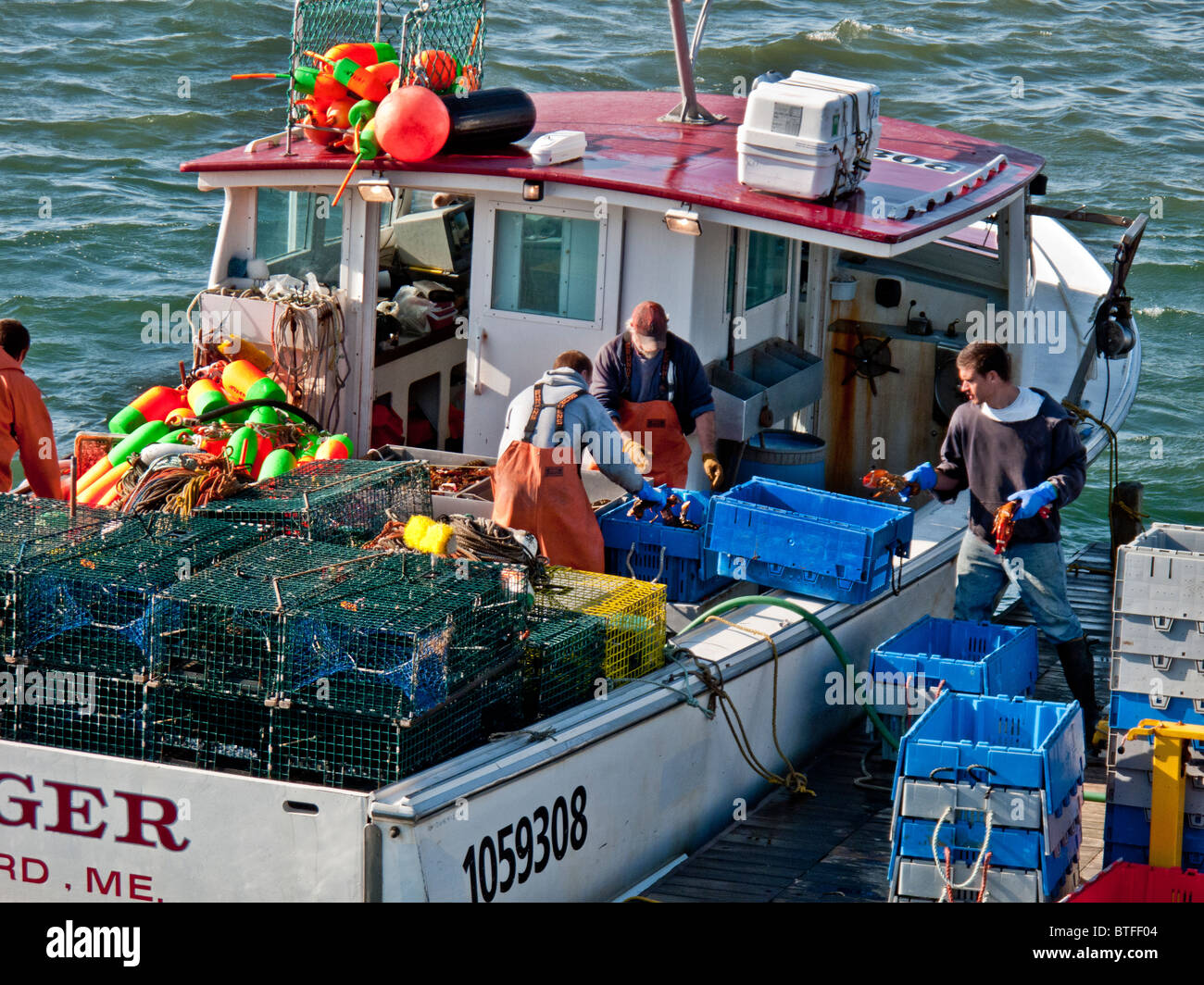 Lobstermen with a full catch unload their boat at a pier in Islesford