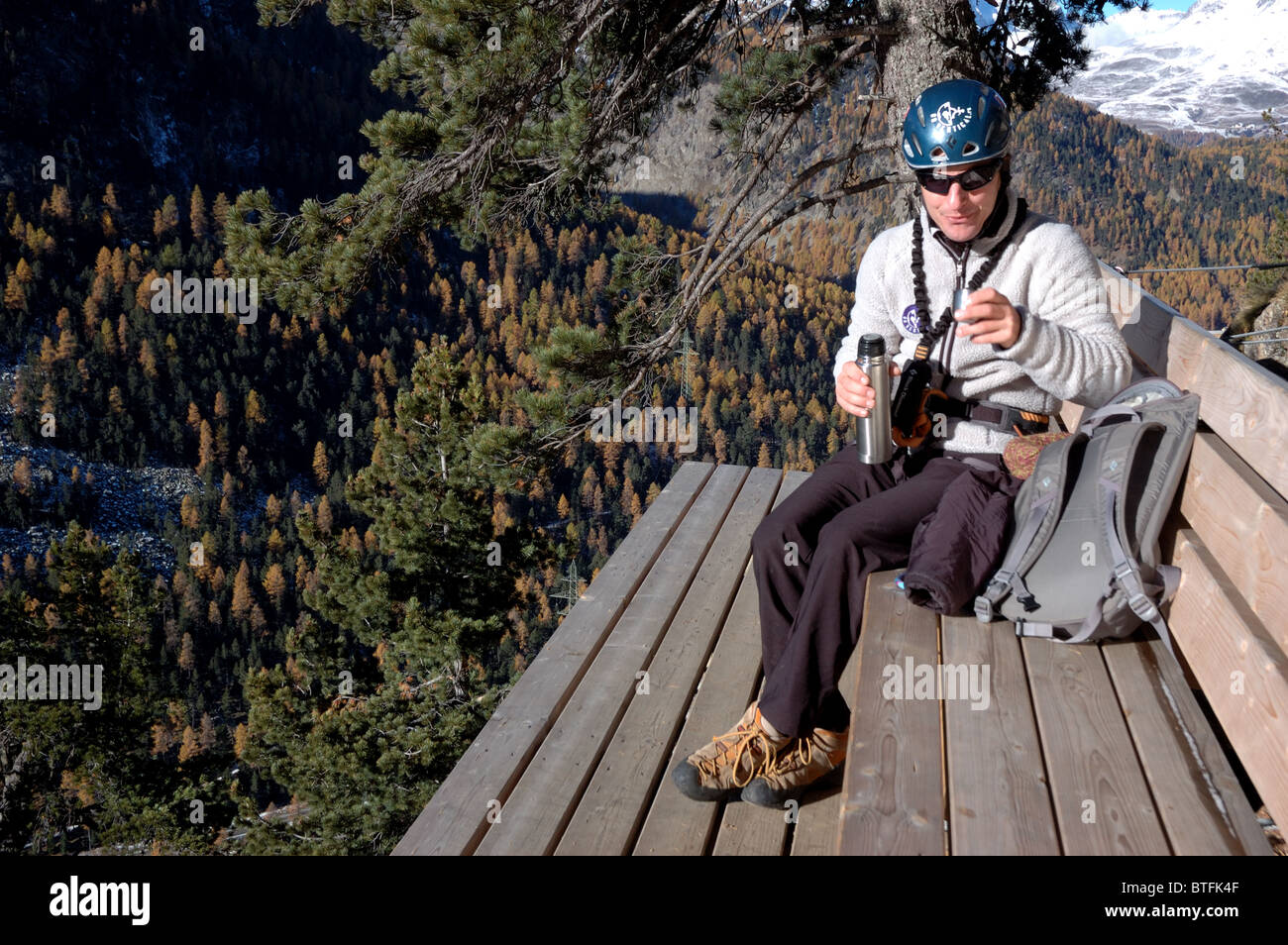 Climber sitting on a bench halfway up La Resgia, a via ferrata in  Pontresina, Engadin St. Moritz, Switzerland Stock Photo - Alamy