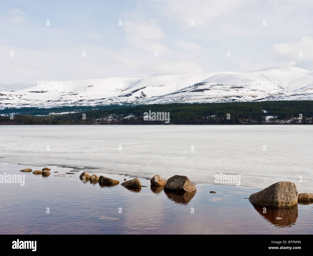 Loch Morlich in the Cairngorms near Aviemore frozen in winter, Scotland, UK Stock Photo