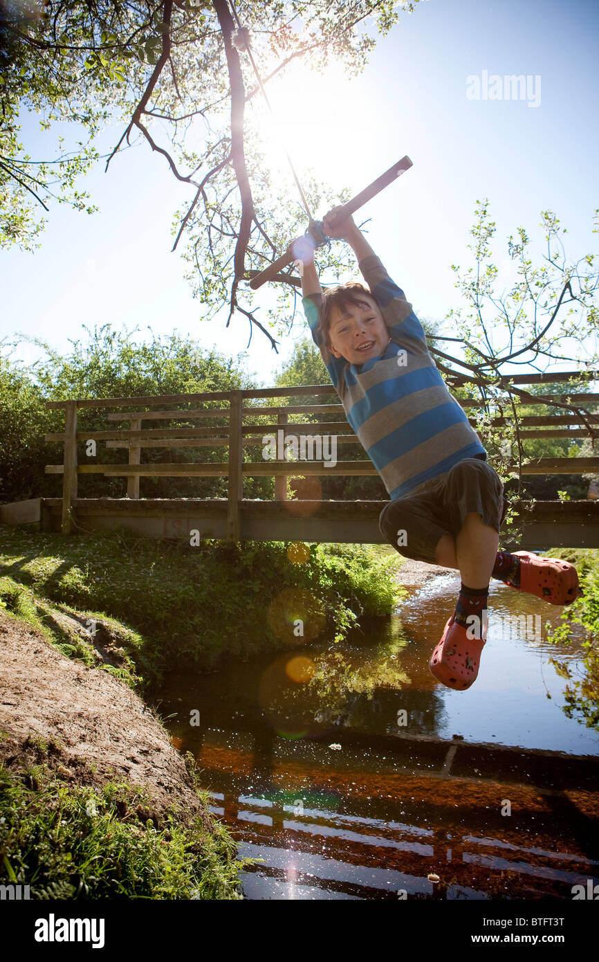 Boy swinging on a rope Stock Photo