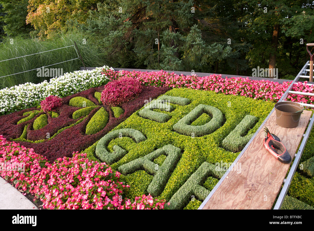 One of the two carpetbeds undergoing a maintenance cut at the entrance to Edwards Gardens, on of many municipal parks in Toronto Stock Photo