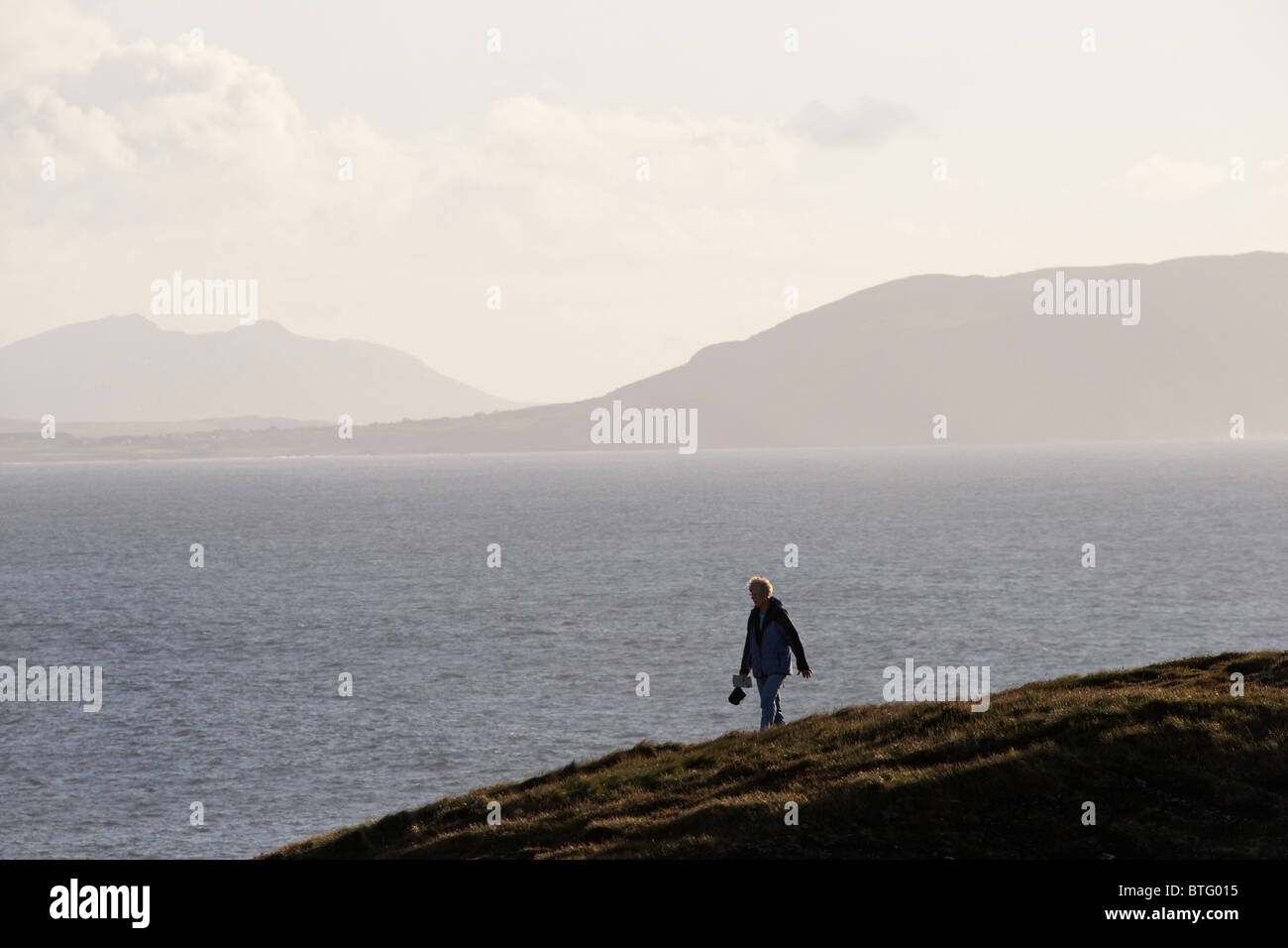 Female walker on the cliffs near Malin Head, Inishowen Peninsula, County Donegal, Ulster, Eire. Stock Photo