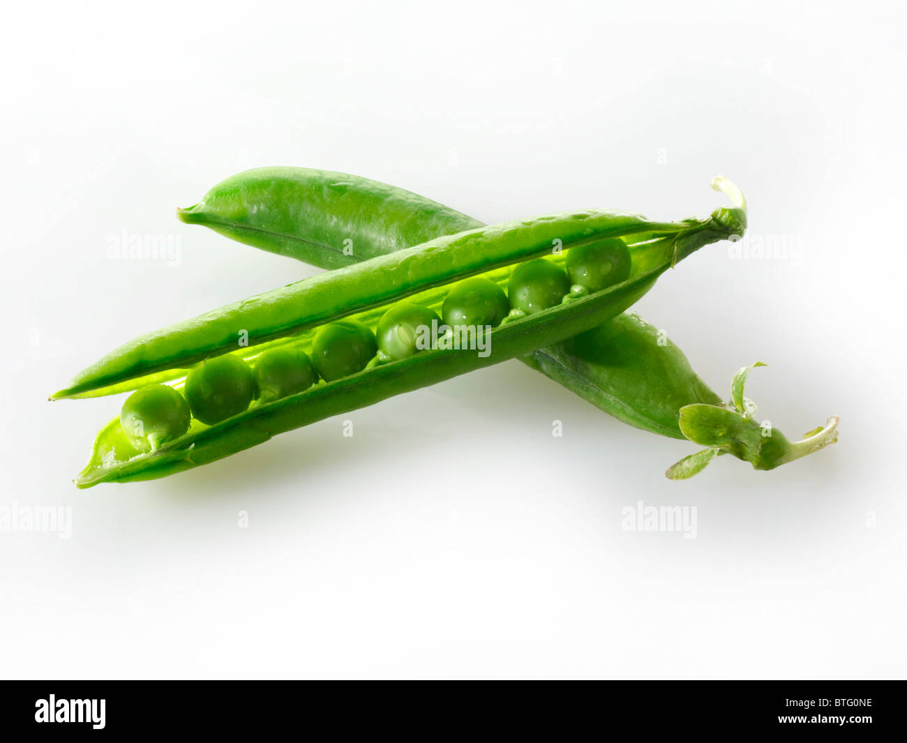 Close up of fresh raw peasin pea pods against a white background Stock Photo