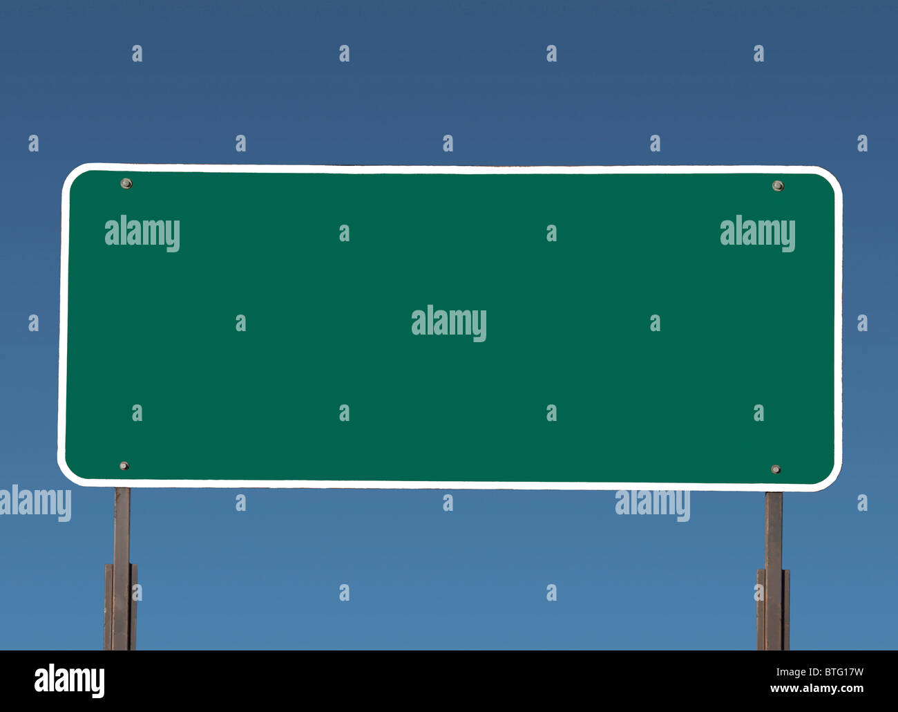 Big blank green highway road sign with gradient blue sky. Stock Photo