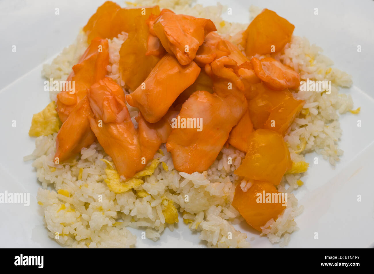 Chicken In Pineapple and Egg Fried Rice Chinese Take Away Food On A White Plate Stock Photo
