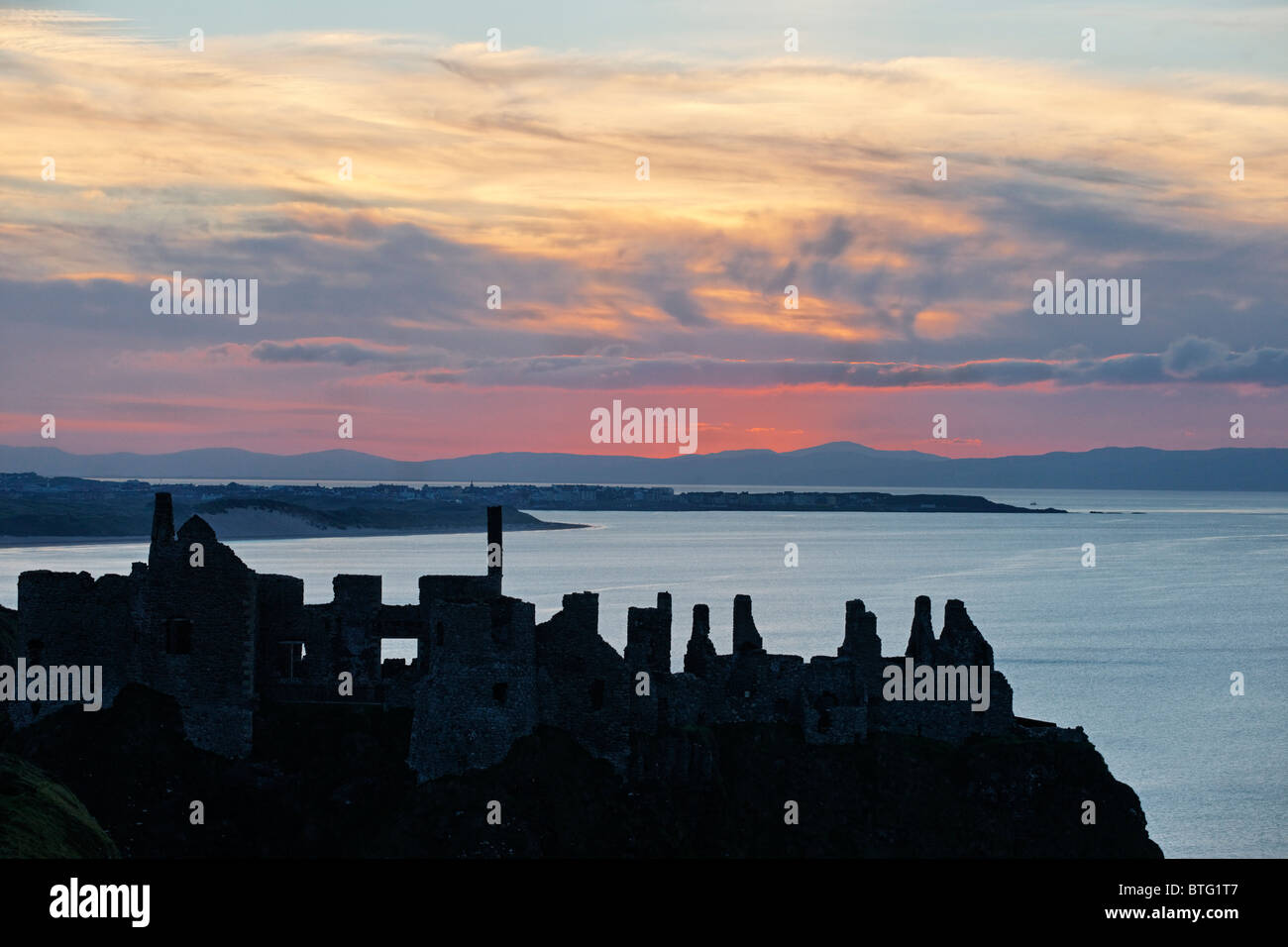 Dunluce Castle, County Antrim, Ulster, Northern Ireland, UK. Silhouette of ruins at sunset. Stock Photo