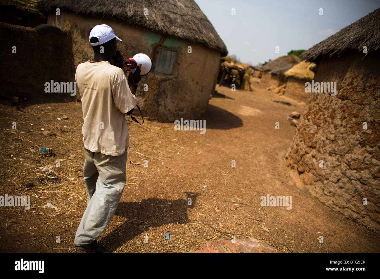 A community volunteer uses a megaphone to announce an upcoming national polio immunization campaign Stock Photo