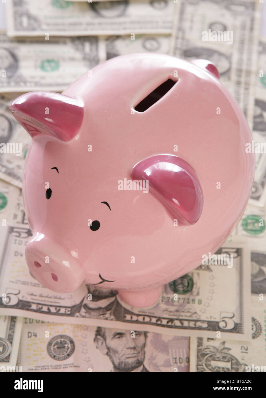 pink piggybank with american dollars Stock Photo