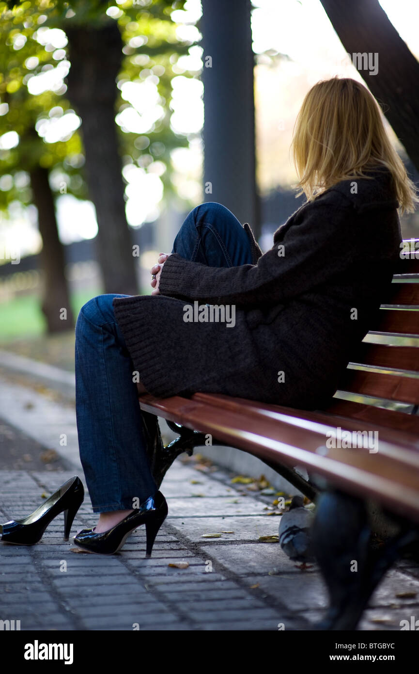 woman sitting on a bench in the park Stock Photo - Alamy