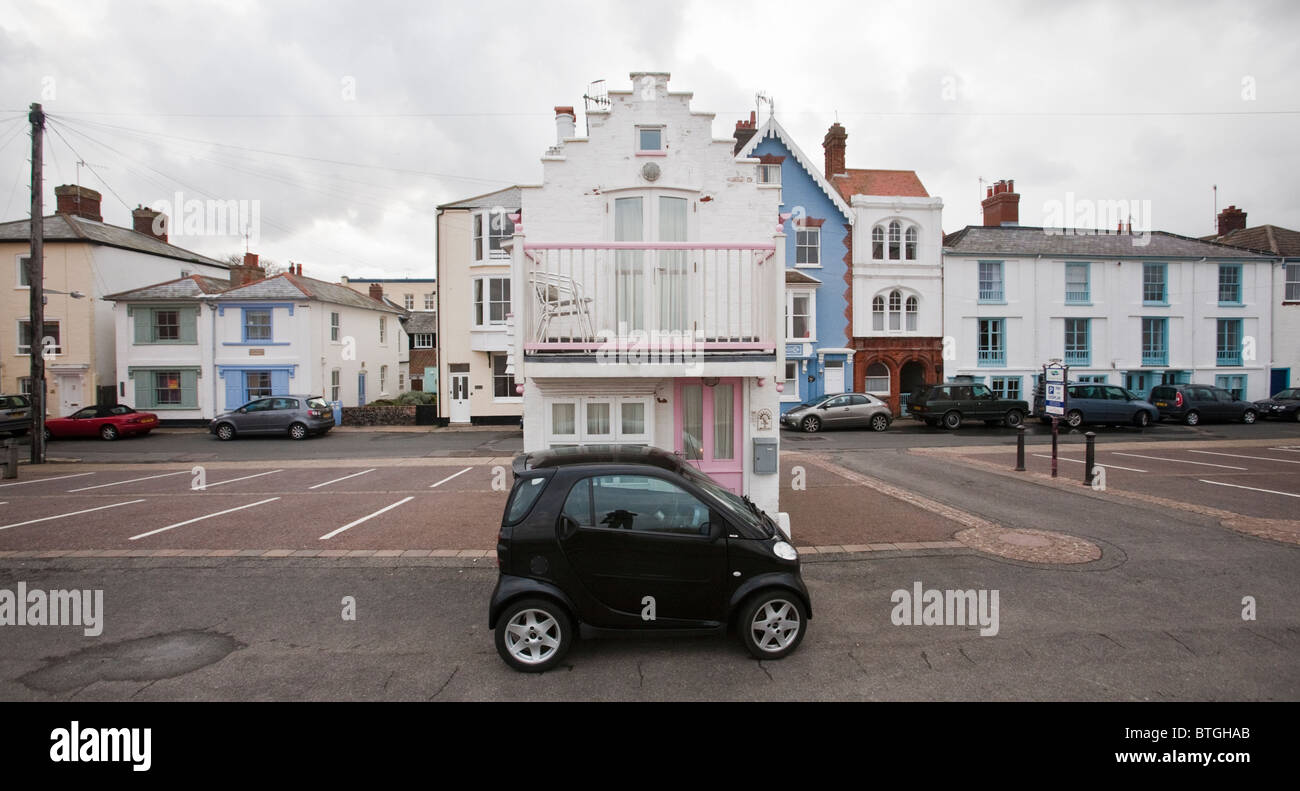A very small house on the sea front at Aldeburgh dwarfed by a Smart car parked in front of it Stock Photo