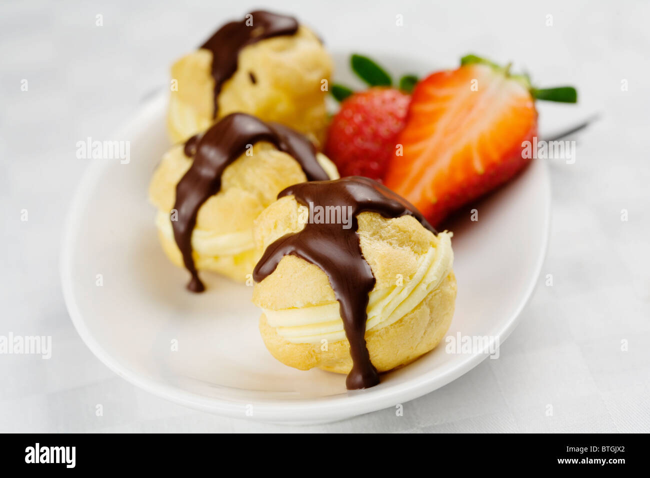 three profiterole on a white dish Stock Photo