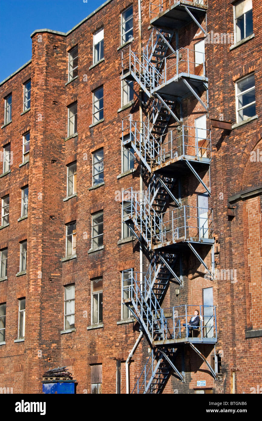 Fire escape tea break, Oxford Mills, adjacent to Ashton Canal, Ashton under Lyne, Tameside, Greater Manchester, England, UK. Stock Photo