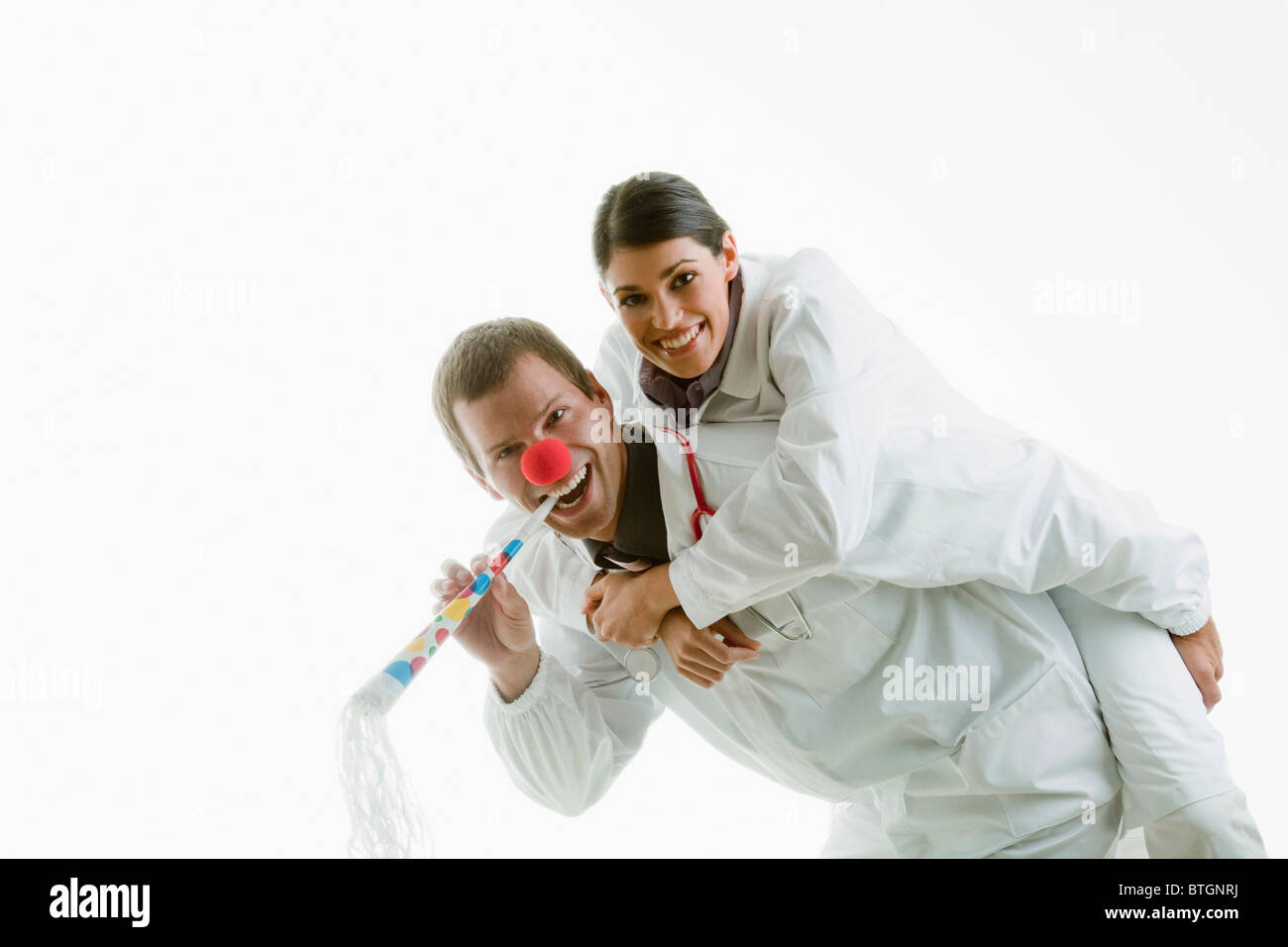 Male and female doctors playing with party toys Stock Photo