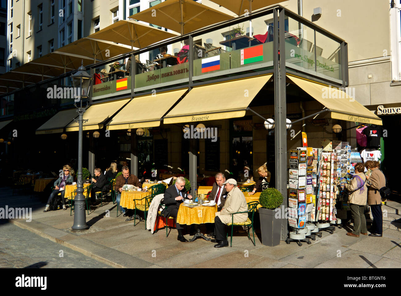 Patrons of corner sidewalk cafe enjoying autumn sunshine in historic old Dresden Altstadt Stock Photo