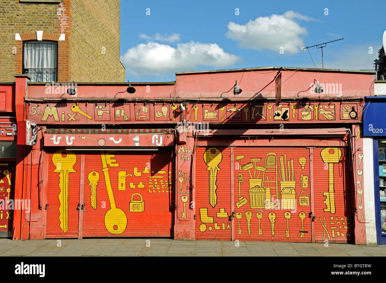 DIY Store with shutters down showing keys and hardware painted on the front, Blackstock Road Finsbury Park N4 London England UK Stock Photo