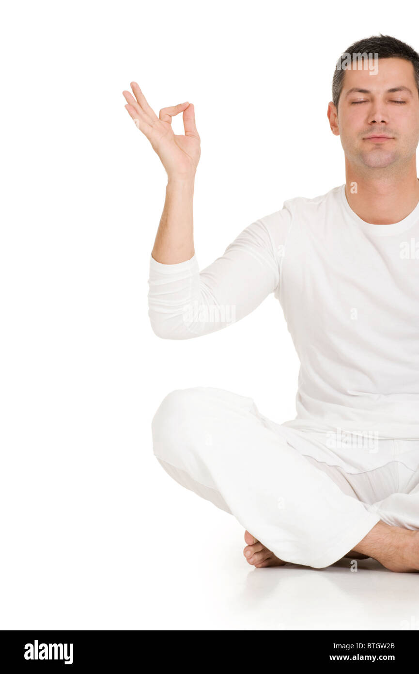 man dressed in white sitting on the floor practicing yoga Stock Photo ...