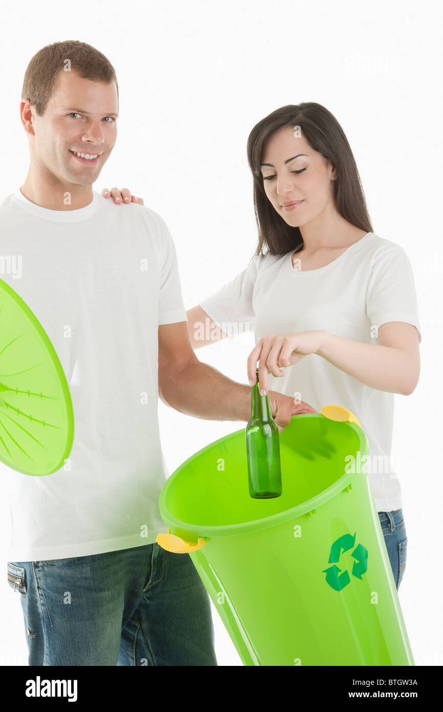 Couple throwing glass bottle in the recycling bin Stock Photo Alamy