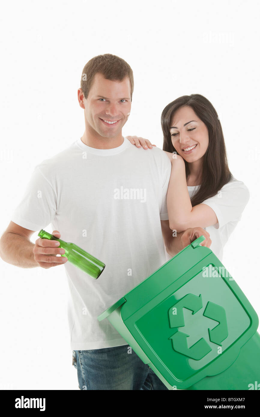 Couple throwing glass bottle in the recycling bin Stock Photo Alamy