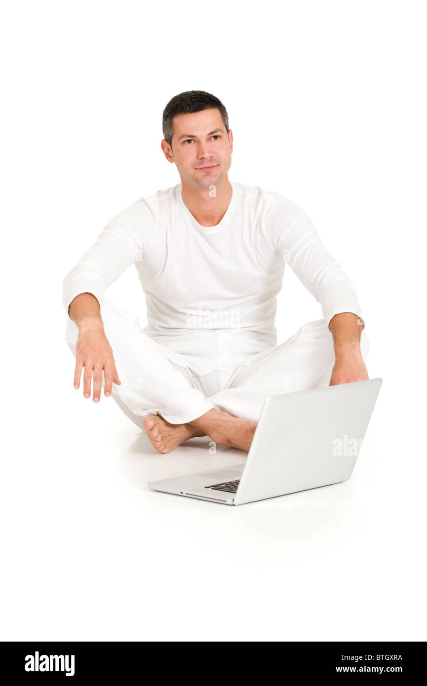 man dressed in white sitting on the floor with laptop Stock Photo - Alamy