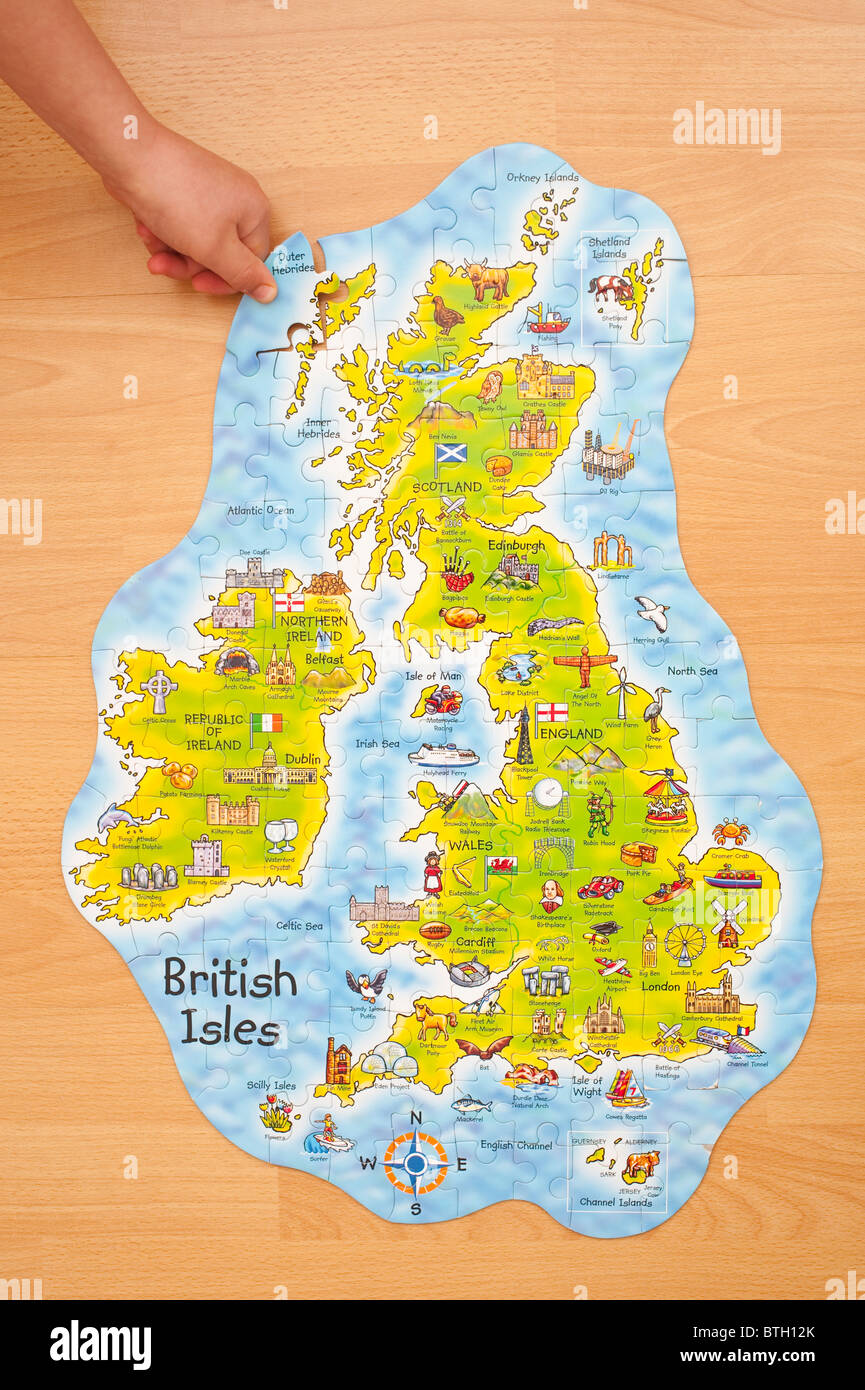 A MODEL RELEASED child puts in the last piece of a jigsaw of the British Isles Stock Photo