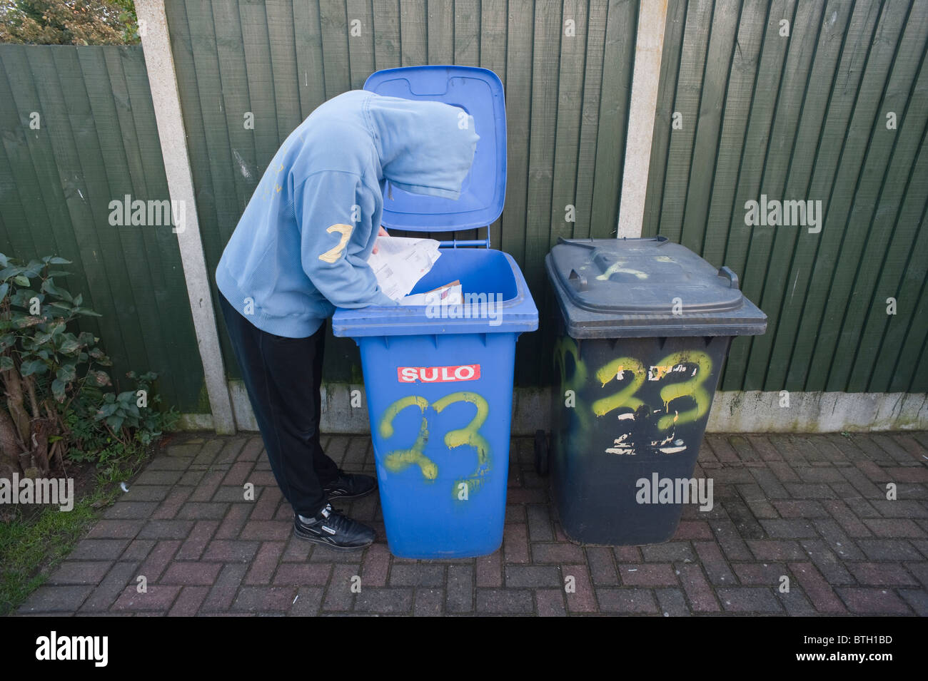 A MODEL RELEASED picture of a hooded male looking through someone's