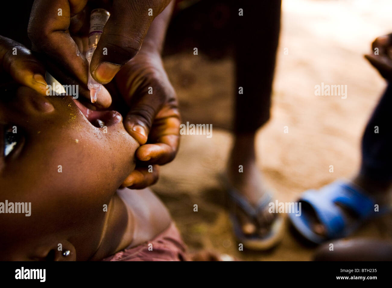 A girl receives two drops of polio vaccine during a national polio immunization exercise in Salaga, northern Ghana Stock Photo