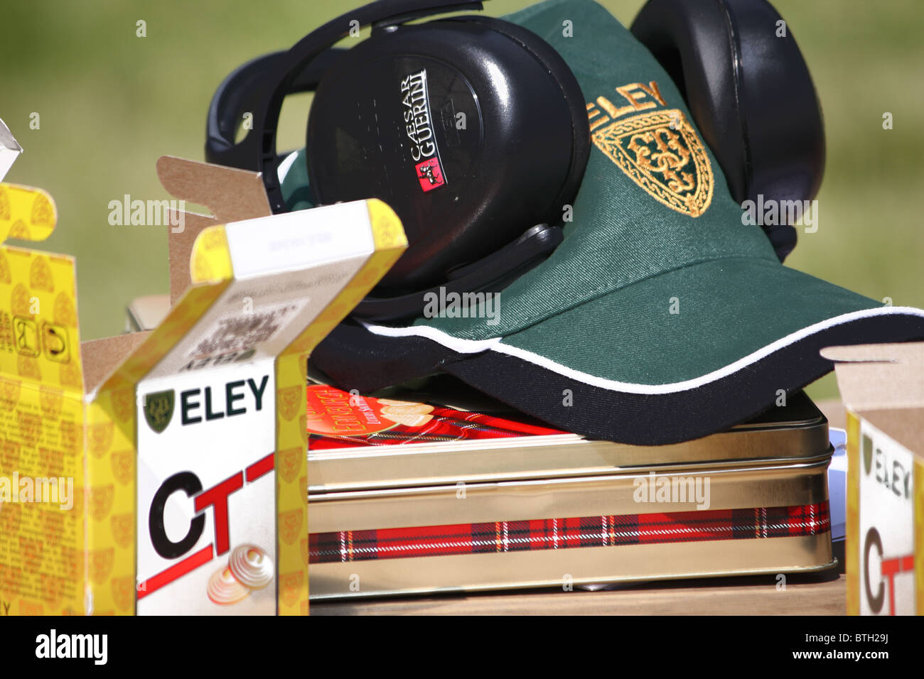 A set of ear defenders for safety at a clay pigeon range with a shooters cap and Eley cartridges ready to use. Stock Photo