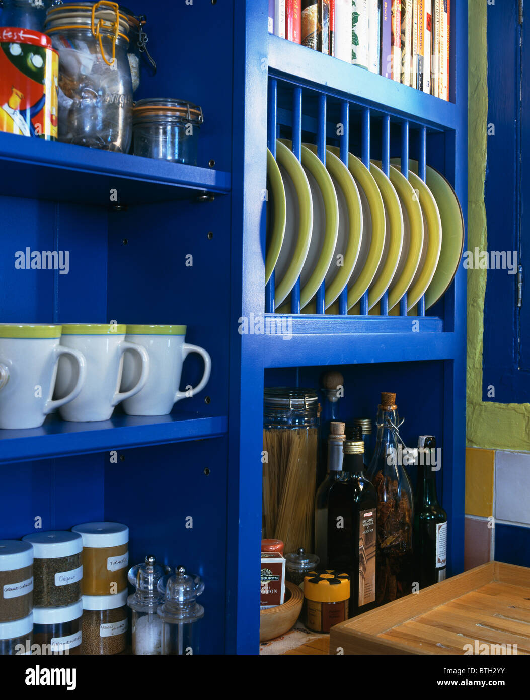 Closeup of limegreenedged white cups and plates on bright blue