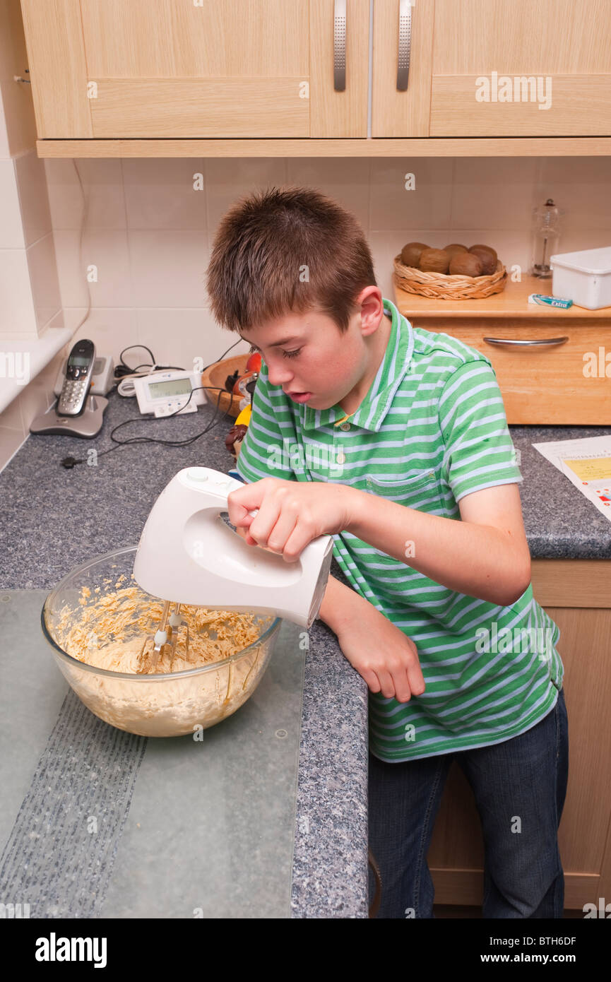 A MODEL RELEASED photo of a ten year old boy mixing cooking ingredients in the Uk Stock Photo