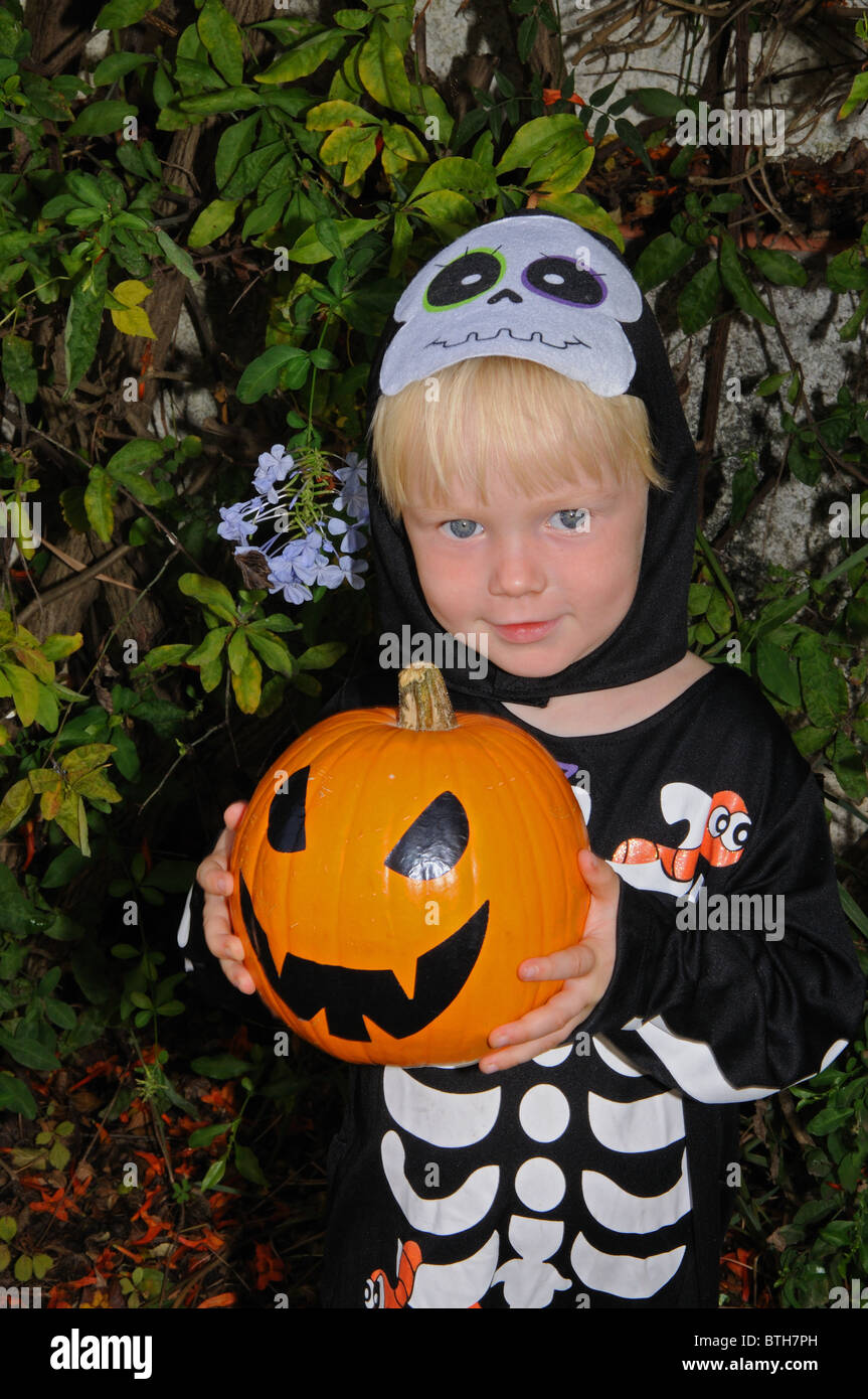 Young boy dressed as a skeleton (holding a pumpkin) for Halloween, Mijas Costa, Costa del Sol, Malaga Province, Andalucia, Spain Stock Photo