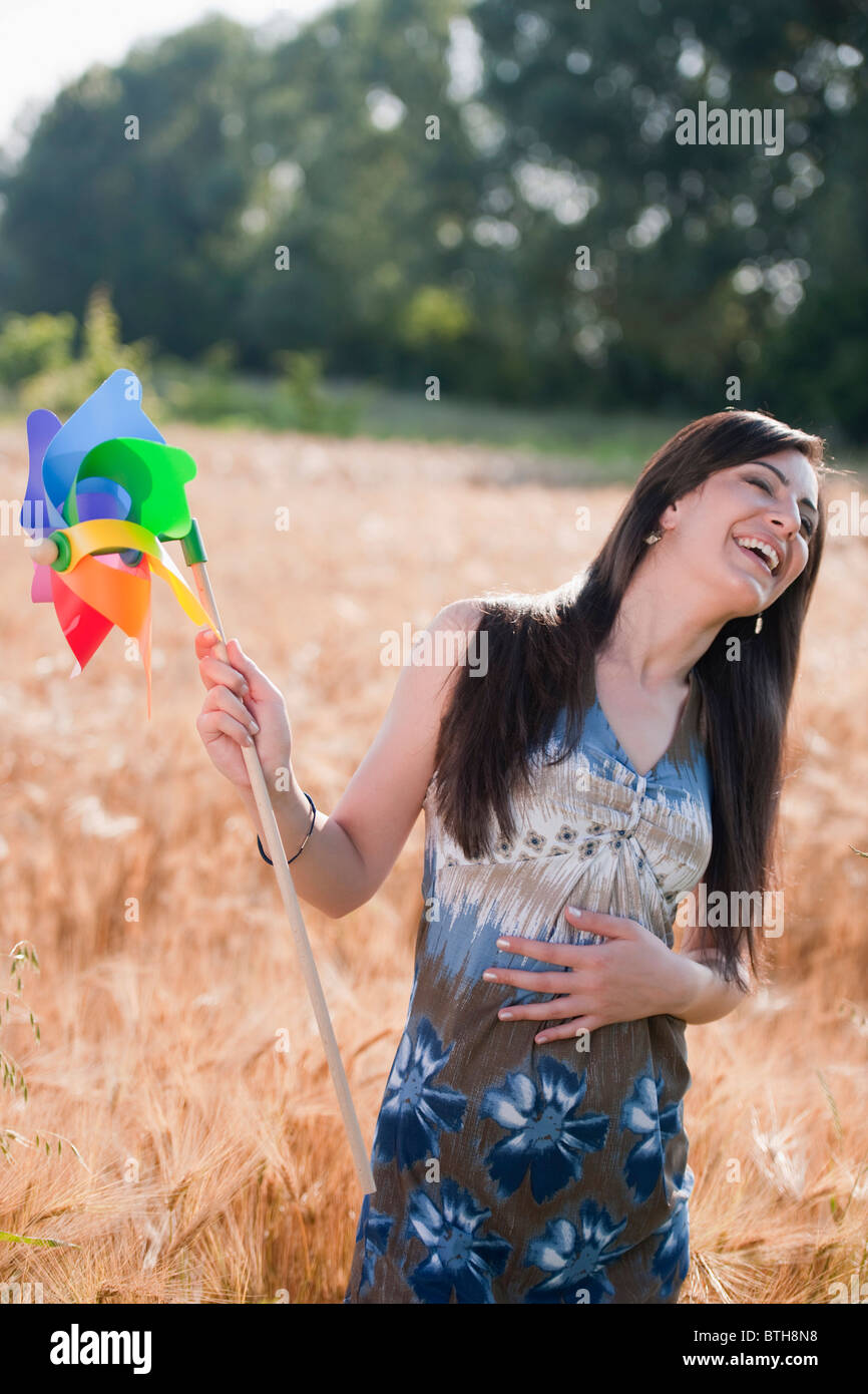 Young woman holding pinwheel in wheat field Stock Photo - Alamy