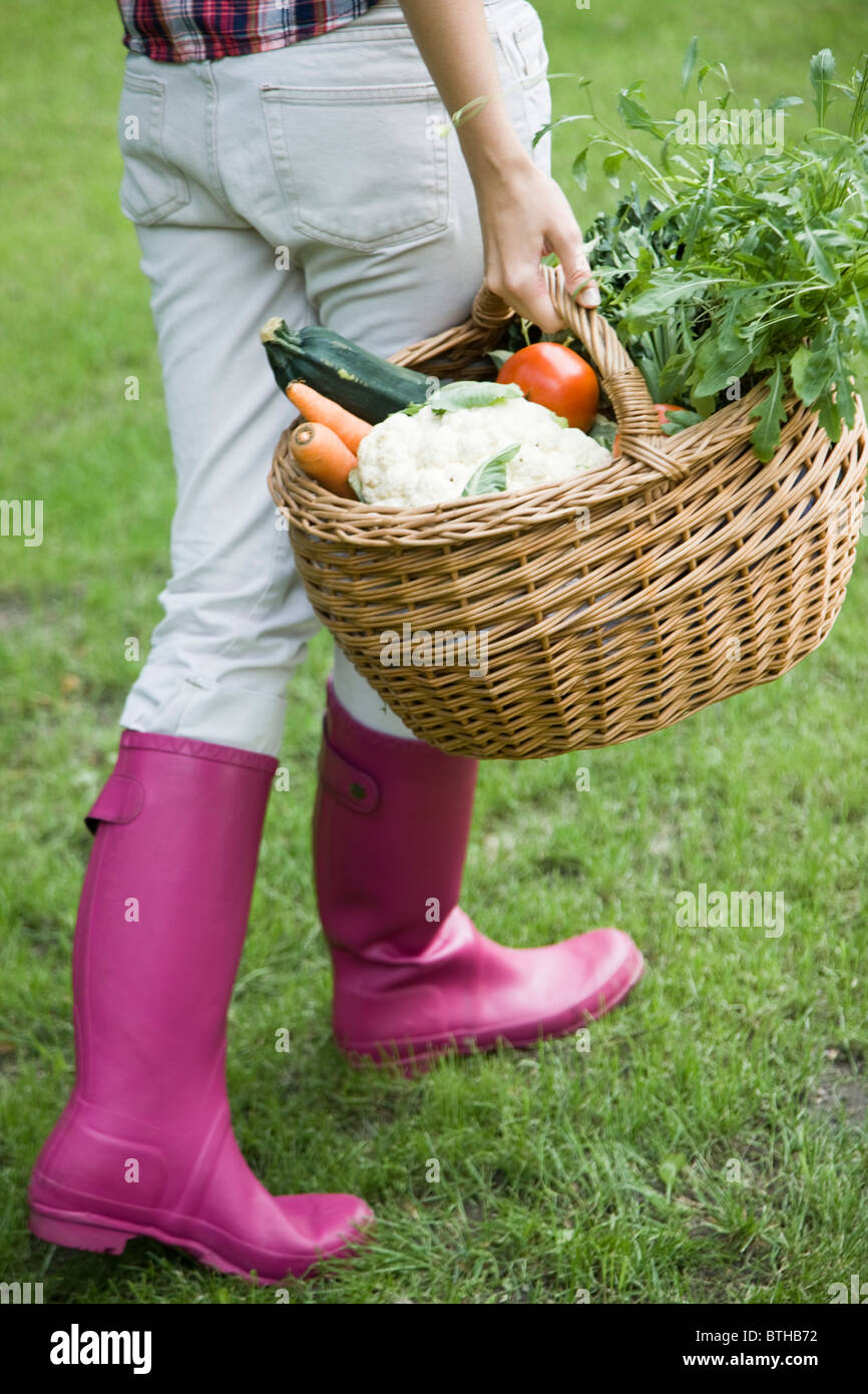 young woman carrying basket with vegetables Stock Photo Alamy