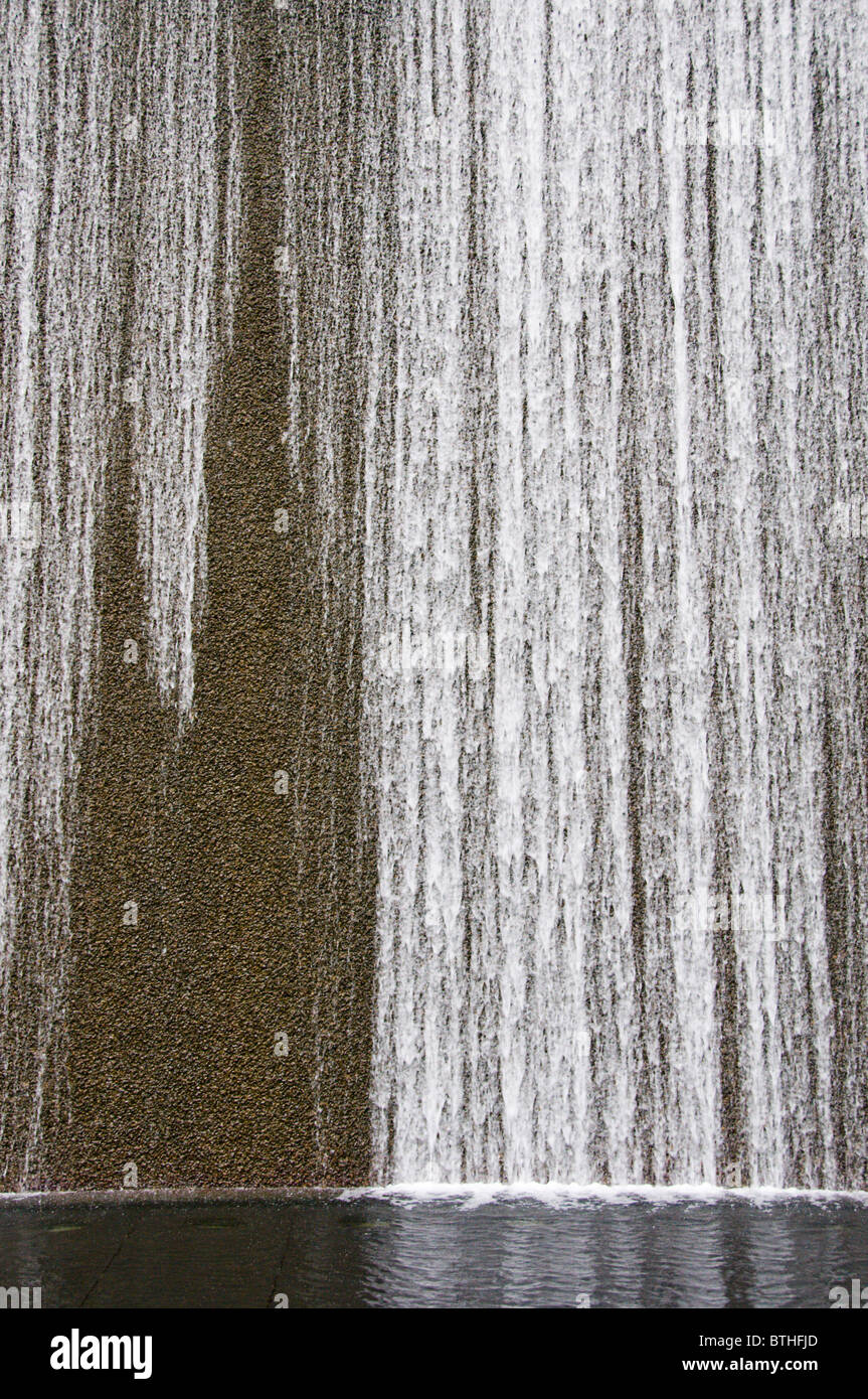 Water cascading down fountain in business district of downtown Singapore Stock Photo