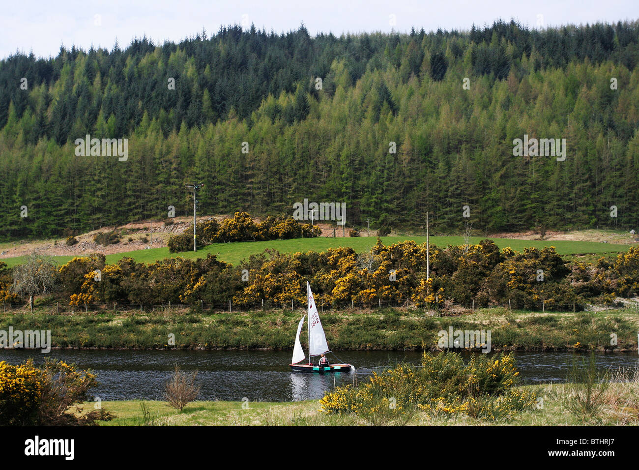 Sailing boat on the Caledonian Canal in Scotland. Stock Photo