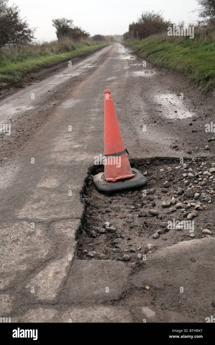 Pothole in road marked with traffic cone Stock Photo