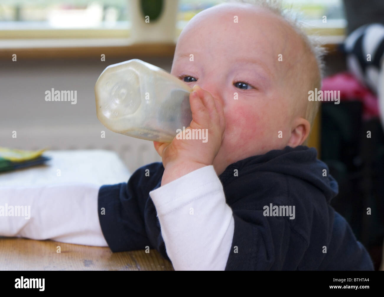 Downs syndrome baby with baby bottle Stock Photo Alamy