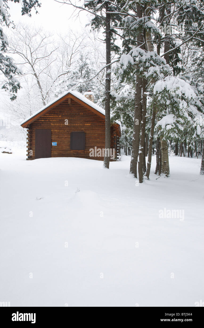 Log building covered in snow in the White Mountains, New Hampshire USA Stock Photo
